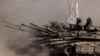 Israeli soldiers sit on top of tanks at the Israel-Gaza border